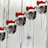 A series of custom photo cupcake toppers featuring a french bulldog wearing a Santa hat, printed on photo paper and attached to lollipop sticks.